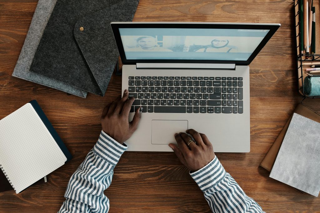 Person Sitting on Table Working on Laptop